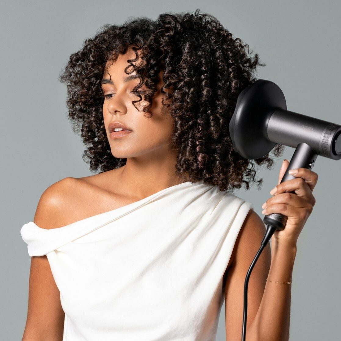 a woman blow drying her hair with a hair dryer